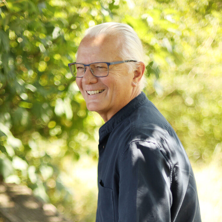 Axel Höltge in dunkelblauem Hemd in der Natur