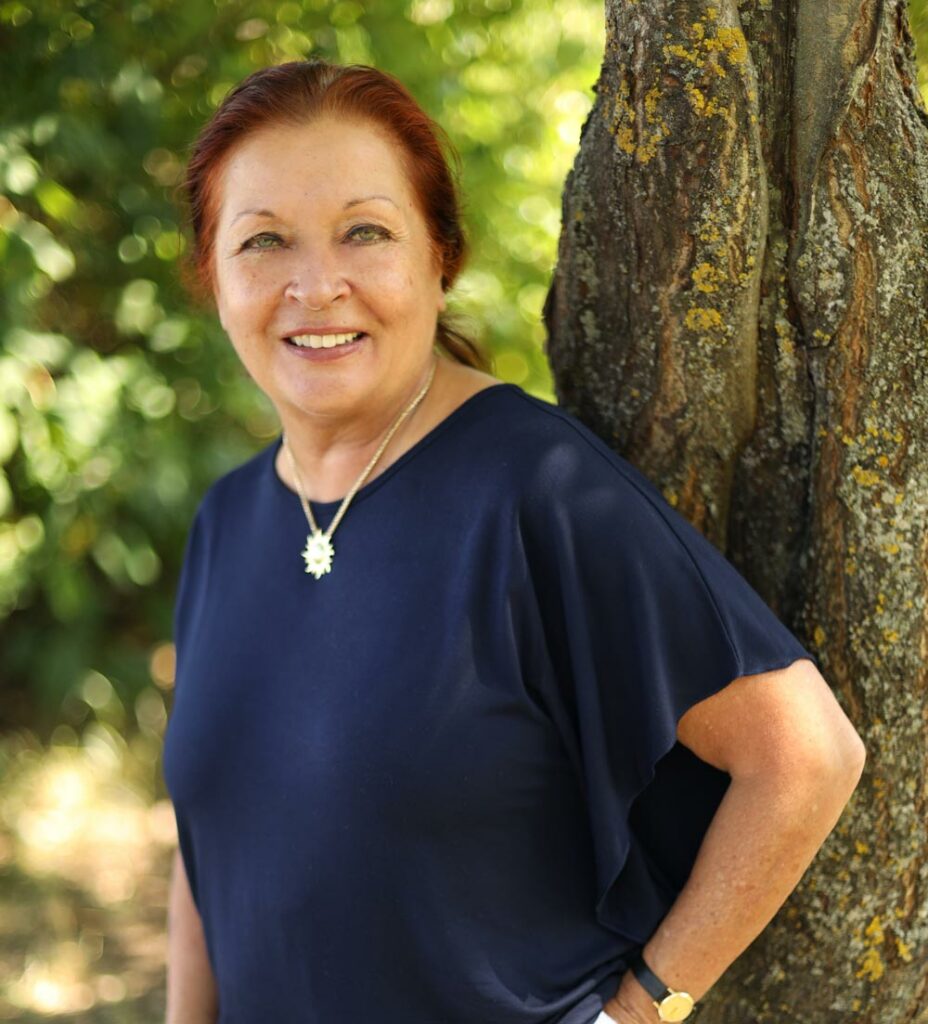 Ursula Höltge in dunkelblauem T-Shirt angelehnt an einem Baum